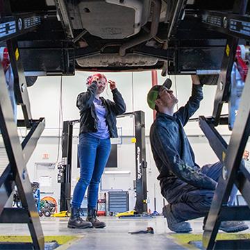 赌钱app可以微信提现 students work on the undercarriage of a vehicle